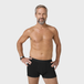 Man in NEW TENA Men Protective Boxers Light, hands on hips, showcasing washable, soft organic cotton boxers with built-in protection for incontinence.