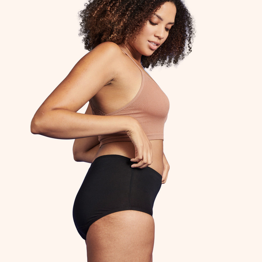 Woman modeling Soft Cotton Classic Washable Underwear for Light Incontinence, showcasing high-cut style and comfortable waistband designed for protection and reusability.