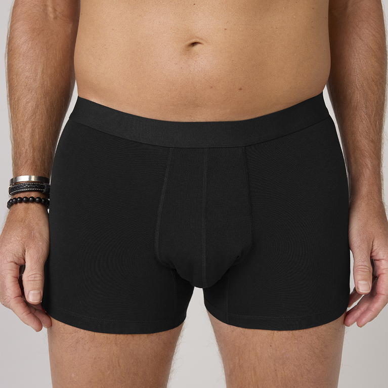 Man wearing NEW TENA Men Protective Boxers Light, demonstrating the fit and design of washable incontinence underwear with built-in protection.