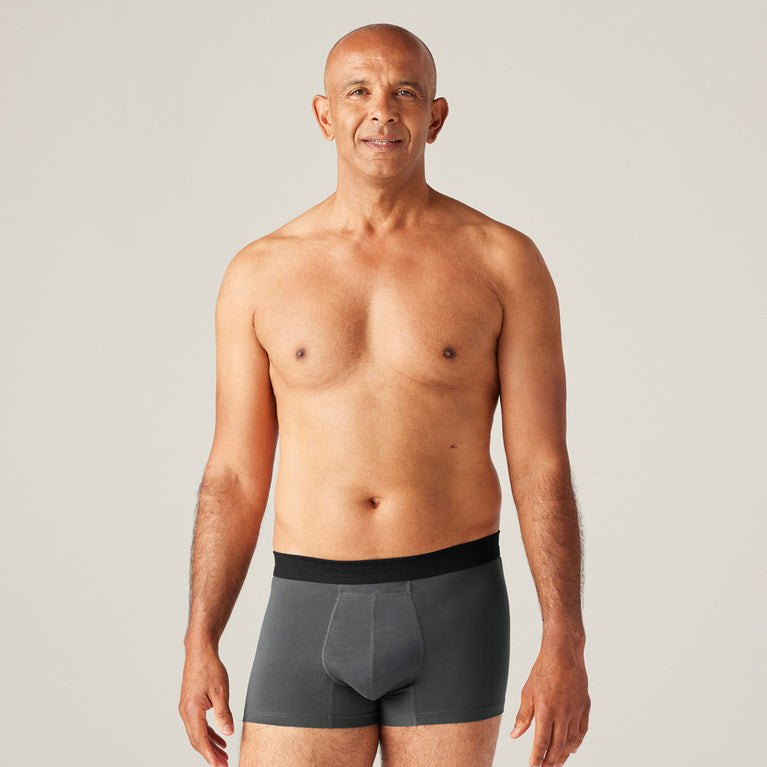TENA Men Protective Boxers Light shown on a shirtless man, highlighting the ergonomic fit and soft cotton material designed for light incontinence protection.