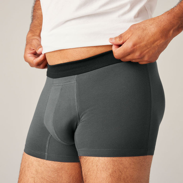 TENA Men Protective Boxers Light, featuring a man wearing grey boxer briefs designed for light incontinence, highlighting a comfortable, discreet fit and built-in Secure Absorption Zone.