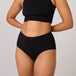 Person wearing TENA 3 Pack Organic Cotton Underwear, showcasing high-waisted, ribbed design offering discreet, comfortable protection for light bladder leaks.