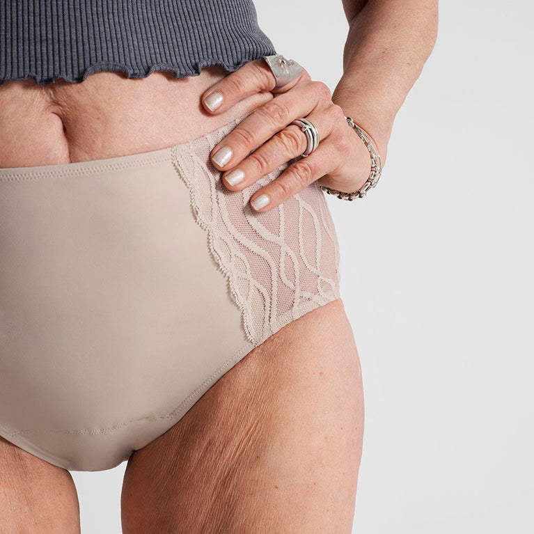Silhouette Classic| Washable Underwear Light Incontinence: Close-up of woman wearing washable beige undies, showcasing ribbed fabric, hand with ring, and discreet design.
