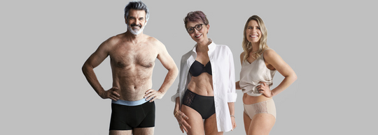 Two women and a man wear different types of washable incontinence underwear, including Sihouette and men's boxers, pose confidently against a plain grey background.