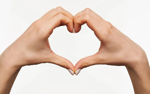 Two hands forming a heart shape against a plain white background.